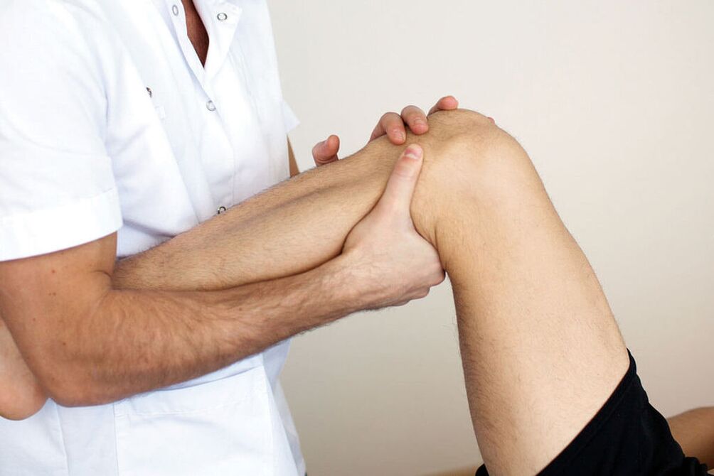 zdravnik pregleduje koleno z artrozo